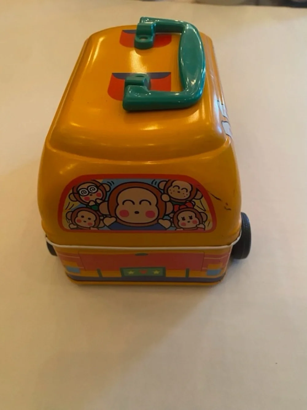 A Sanrio Yellow Toy Bus Metal Carry Case with Teal Handle
